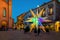 Illuminated colorful Christmas star on town square in Italy.