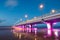 Illuminated concrete pier, long exposure shot at sunset