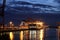 Illuminated Container Ship / Freighter at Dusk / Night Magic Hour in the port of Hamburg with big Gantry Cranes Container