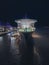 Illuminated cruise ship docked in a picturesque harbor in the evening.