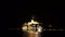 Illuminated cruise ship stands off the coast at night