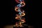 an illuminated dna helix model in a dark room