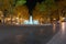 Illuminated fountain and tree lined promenade long exposure nigh