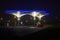 Illuminated futuristic gas station at night