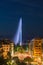 Illuminated Geneva Water Fountain Jet d`Eau - the city`s most famous landmark - summer evening view with blue sky, Geneva,