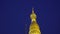 Illuminated Golden Pagoda Spire Against Night Blue Sky