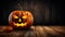 Illuminated halloween pumpkin on wooden planks with copy space