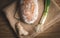 Illuminated handmade bread on wooden table wwith jute decor. Close up photo of Homemade bread with bunch onion and ginger top