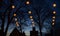 Illuminated Herrnhuter Moravian Christmas stars hanging above the dark silhouettes of old house gables and big trees against a