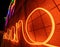 Illuminated letters and words made with neon lights and LEDs of many colors with a vanishing point in the background. Wires and