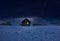 Illuminated log cabin in winter night