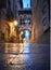 Illuminated medieval street Carrer del Bisbe with Bridge of Sighs in Barcelona at twilight