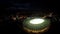 Illuminated modern stadium, lights sparkling in night megalopolis, aerial view