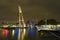 Illuminated old cranes and modern office buildings at night in historical harbor of Rotterdam