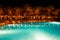 Illuminated pool at night with tropical palms