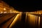 Illuminated shores on the river Arno in Pisa at night, dark and lively location for summer nightlife, used by students, tourists