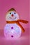 Illuminated snowman on pink background