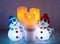Illuminated snowmen and flickering candles
