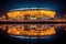 illuminated sports stadium reflecting on water