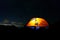 Illuminated tent under the starry night sky