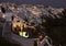 Illuminated whitewashed houses with terraces and pools and a beautiful view in Imerovigli on Santorini