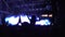 Illumination flashing on stage, silhouettes of audience enjoying rock concert