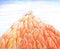 Illustration drawn by hand with colored pencils, a large pointed rock of orange rounded stones against a blue sky with clouds