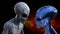 Illustration of a gray alien looking at a blue extraterrestrial in space with a red and green nebula in the background