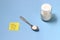 Illustration for healthy life style, salt at tea spoon, shaker, with yellow sticky paper note with text eat less salt, at blue bac