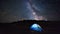 Iluminated tent under stars in the mountains