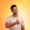 Im good, I hope youre too. a young man showing thumbs up while standing against a yellow background.