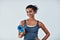 Im happy, healthy and ready for anything. an attractive young woman posing with her yoga mat against a grey background.