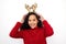 Im just here to spread some Christmas cheer. Studio shot of a young woman wearing a reindeer antlers headband against a