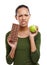 Im meant to choose the apple. Portrait of a young woman trying to decide between chocolate and an apple isolated on