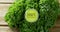 Image of 100 percent natural text over green kale on wooden background