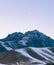 Image of an abandoned house in the valley with snow covered mountains behind