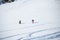 Image from afar of two sporty skiers in snowy resort