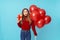 Image of amusing blonde woman holding gift box and balloons