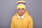 Image of angry aggressive Caucasian hipster man wearing beanie hat and yellow casual hoodie, arguing with somebody, looking at