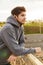 Image of athletic sportsman using earphones while leaning on railing