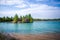 Image of azure river, hilly coast with green trees