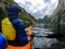 Image from back of female tourist with paddle canoe floating along river