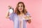 Image of beautiful confused woman holding alarm and cake