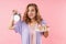 Image of beautiful confused woman holding alarm and cake