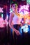 Image of a beautiful girl in an amusement park in a room with neon light. Entertainment concept