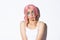 Image of beautiful indecisive girl in halloween costume and pink wig, looking at upper left corner doubtful, standing