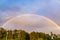 Image of a beautiful rainbow above the trees, double rainbow