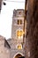 Image of a bell tower near a church with illuminated windows, captured in Caserta Vecchia, Italy