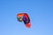 The image of `Best` Kitesurfing sport brand, the kite is in Red, Black and purple flying on the blue sky.