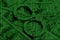 Image of the binary code from bright green figures, through which handcuffs, lying on US dollars